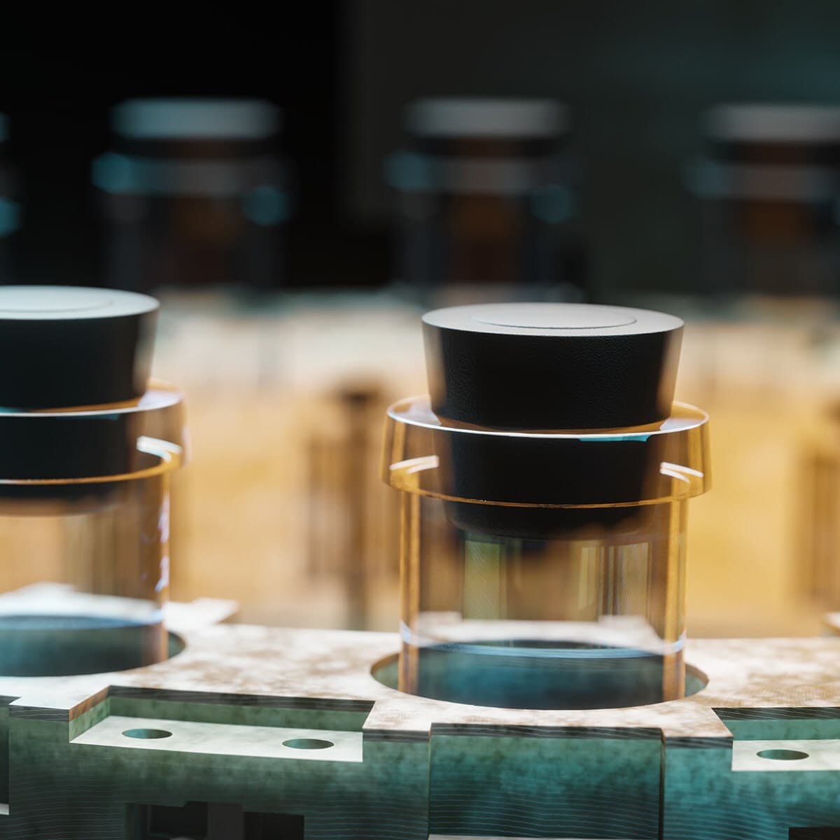 Close-up of glass jars with black lids on a conveyor in a manufacturing setting; foreground jars are sharp, background is blurred.