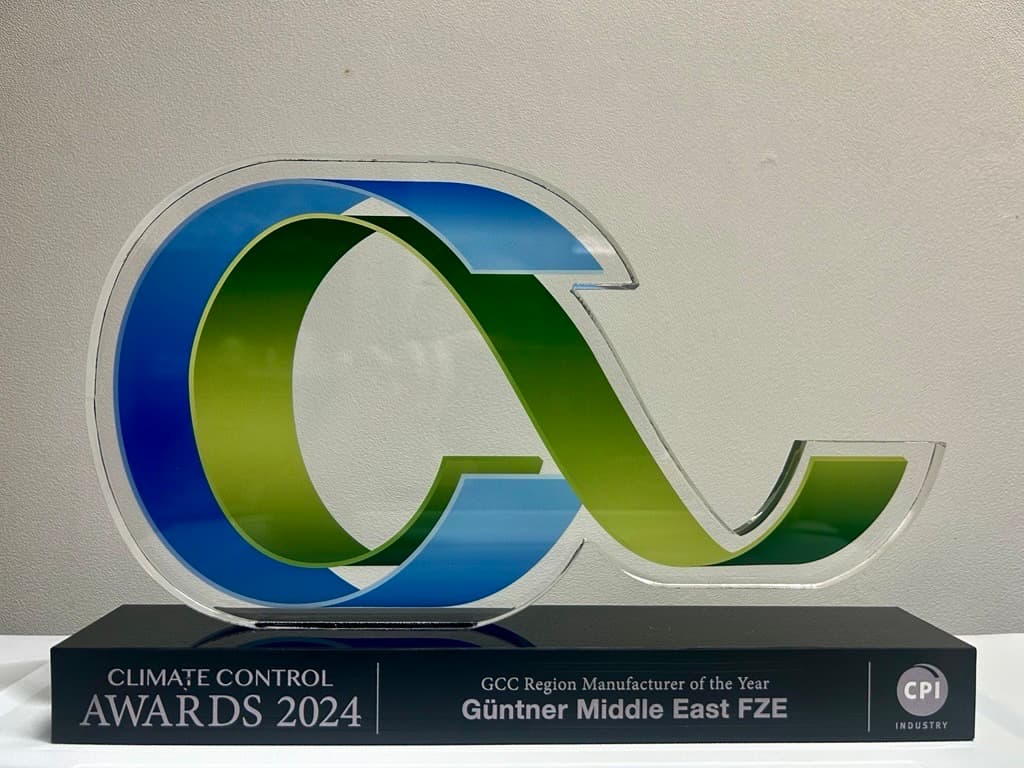 Large acrylic award with overlapping blue and green 'CC' letters mounted on a black base, inscribed "Climate Control Awards 2024" and "GCC Region Manufacturer of the Year."