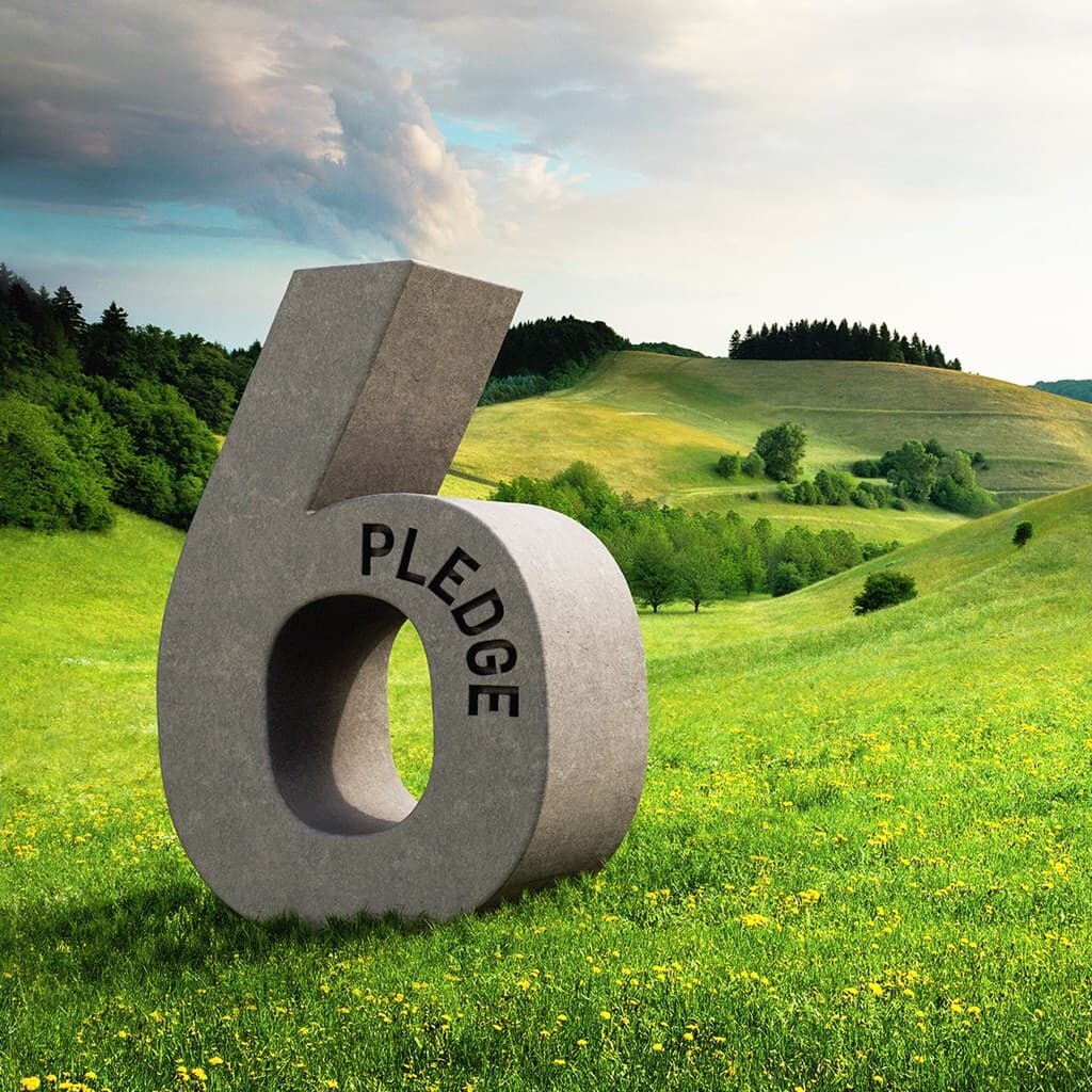 Large gray sculpture of the number 6 with a hollow center, inscribed 'PLEDGE', set in a grassy rolling countryside under a blue, cloudy sky.