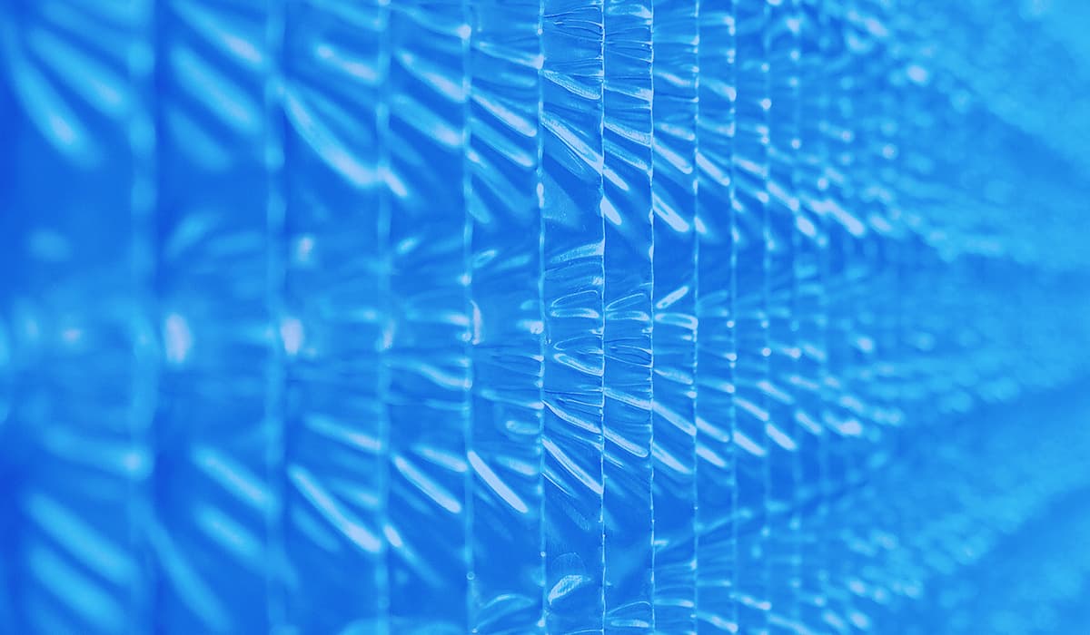 Close-up of a blue translucent plastic surface with repeating rectangular panels and glossy highlights.