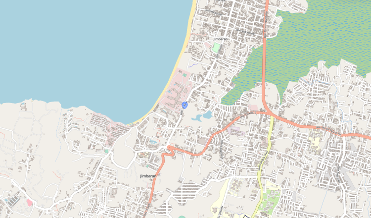 Map of Jimbaran coastal area with a blue pin near the beach, showing winding streets, a red bypass road, and nearby urban blocks.